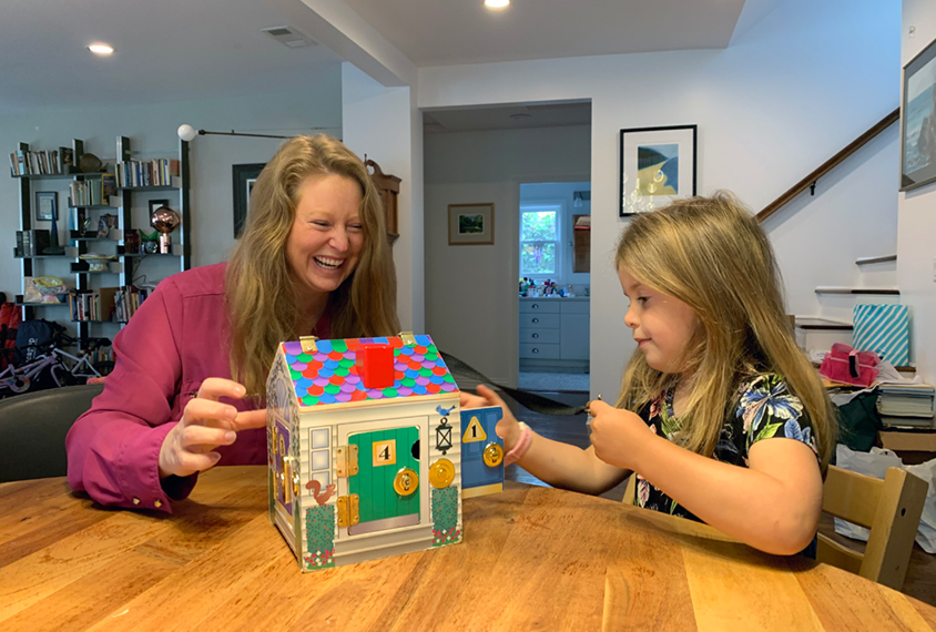 Our graduate student, Kourtney plays with a house during a BOSCC assessment with a child.